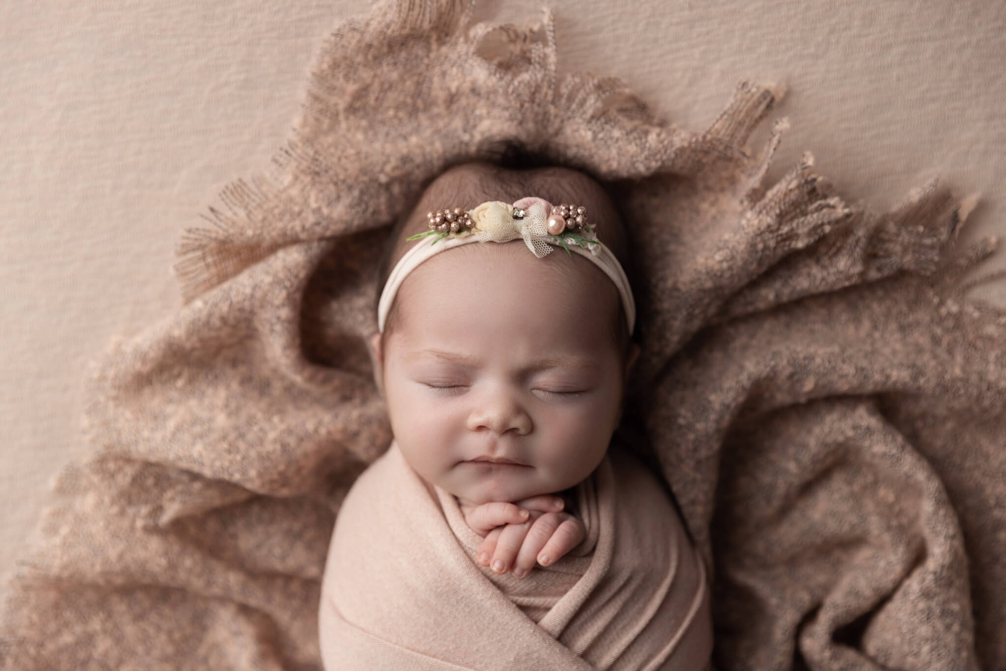 Photo of baby swaddled with brown background